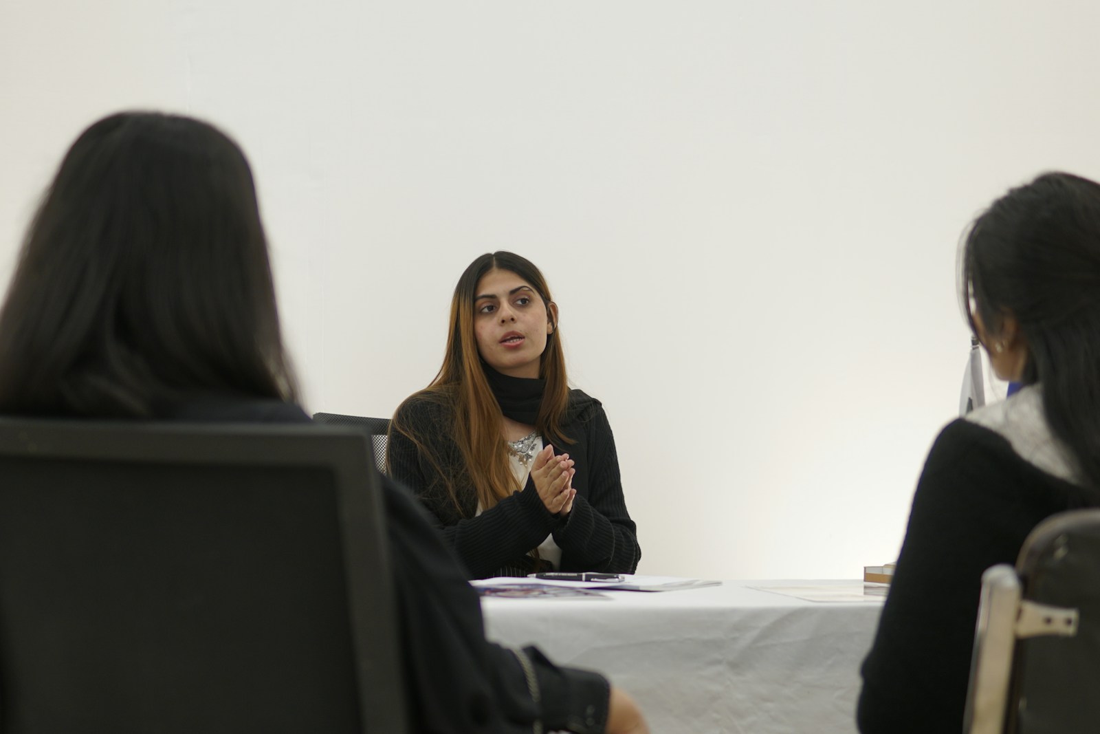 Woman speaking to two people across table